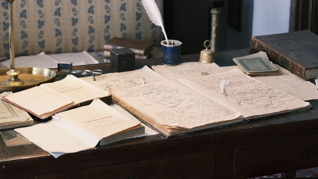 图 / Pexels · Михаил Крамор Cozy study with vintage desk, open books, and quill for a classic literary feel.