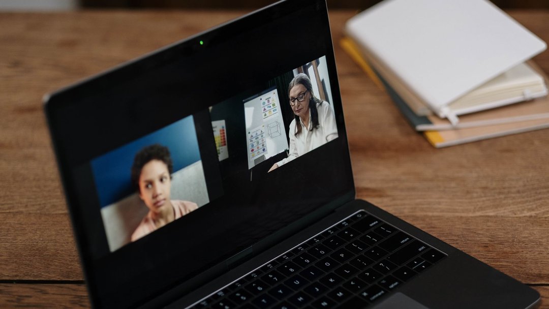 Two people engaging in online education via a laptop, perfect for illustrating virtual learning.