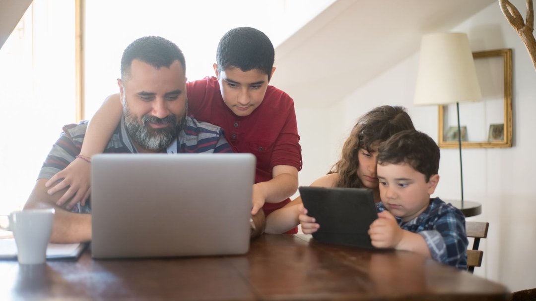 图 / Pexels · Kampus Production Father and kids engaging with a laptop and tablet in a cozy home setting.