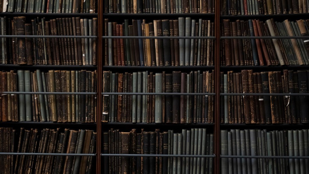 图 / Pexels · Bo Ponomari A close-up of vintage books on library shelves in London, showcasing an abundance of literary history.